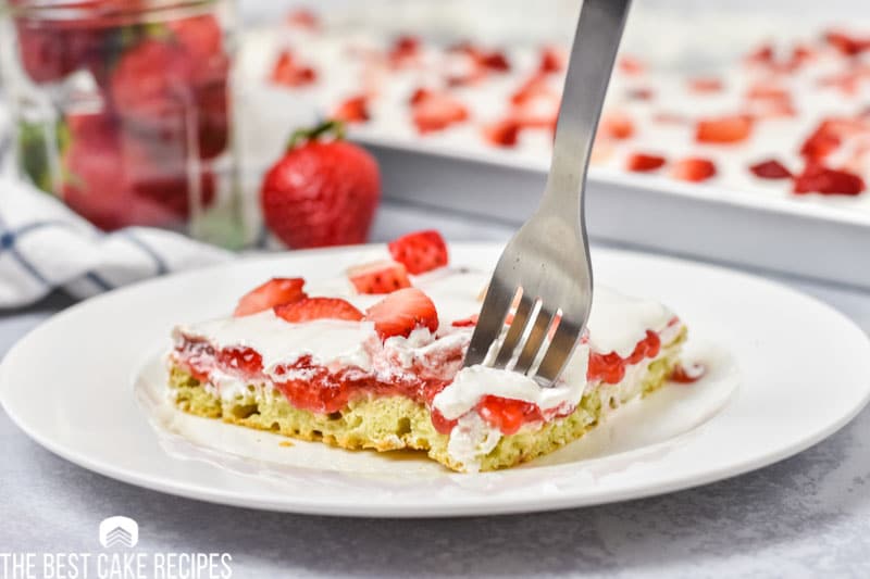 strawberry sheet cake on a plate with a fork