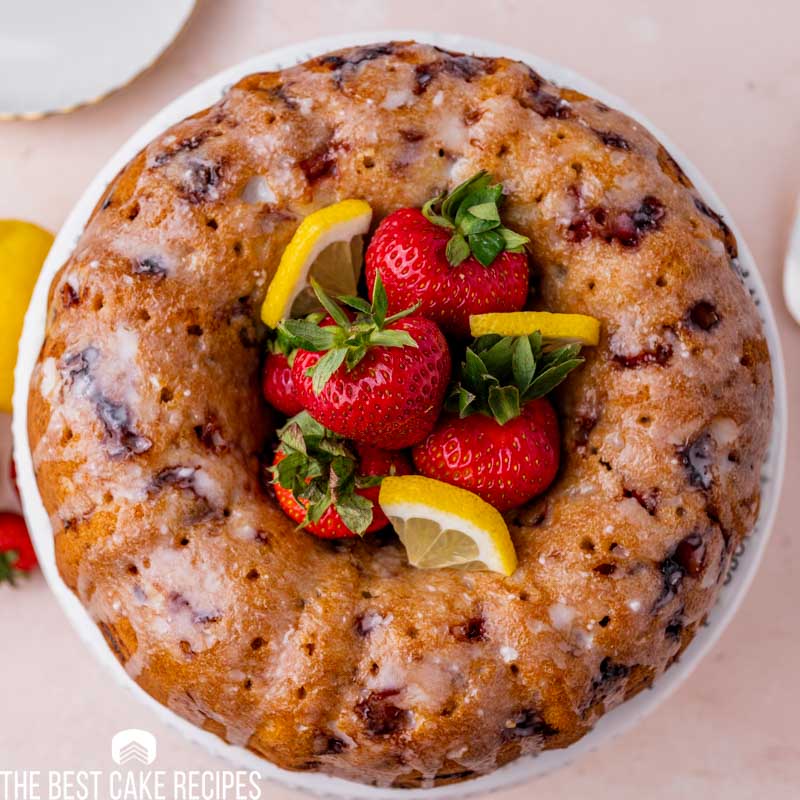overhead view of bundt cake with strawberries and lemon