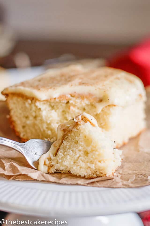 christmas cake with eggnog on a table, with a bite on a fork