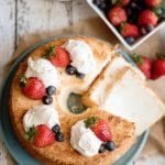 overhead view of an angel food cake with fresh berries and cream