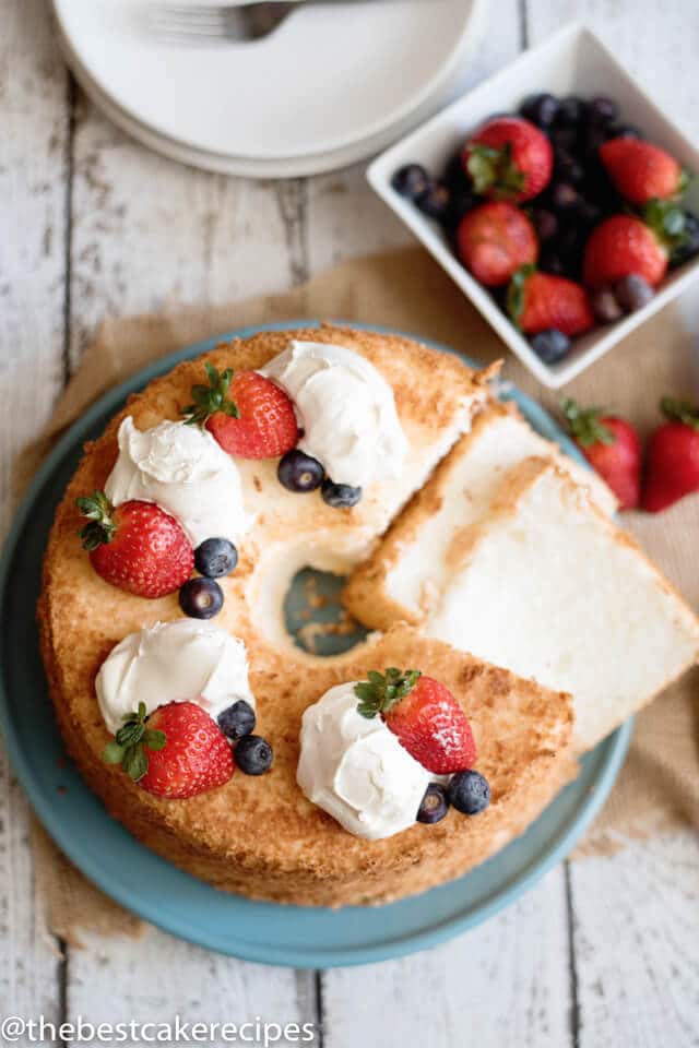 overhead view of an angel food cake with fresh berries and cream