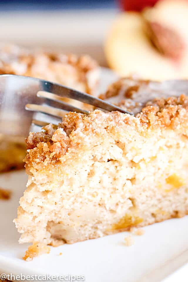 peach coffee cake with streusel on a plate with a fork