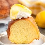 lemon pound cake on a plate with whipped cream and lemon