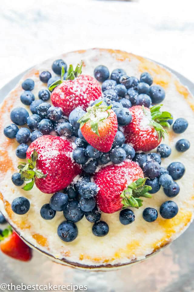 overhead view of blueberry and strawberry topped cake