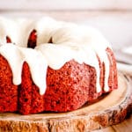 red velvet bundt cake with cream cheese glaze on a wooden plate