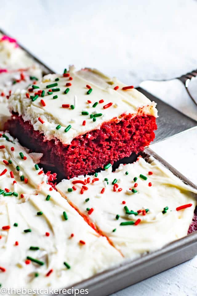red velvet cake with frosting and sprinkles on a spatula