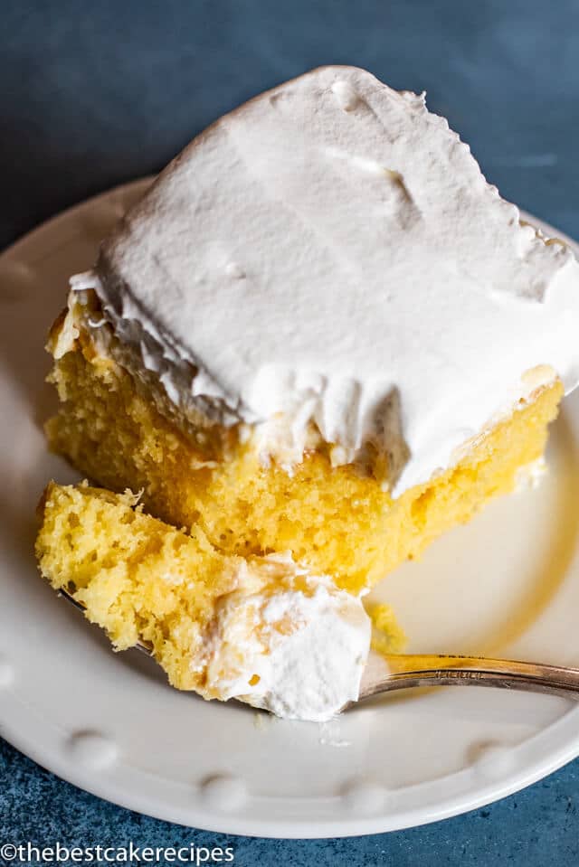 Pineapple Cream Cake with whipped topping on a plate with a fork