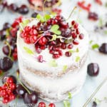 A close up of a cake with fruit on a plate, with Pomegranate and butter Cream