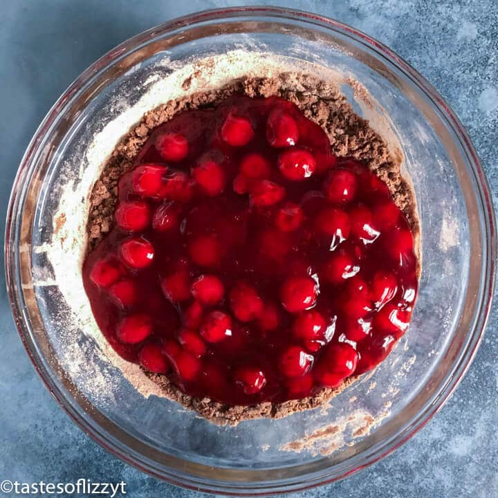 cherry pie filling in cake batter in a bowl