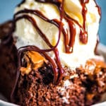 bowl of chocolate drizzled Coca Cola Cake with ice cream