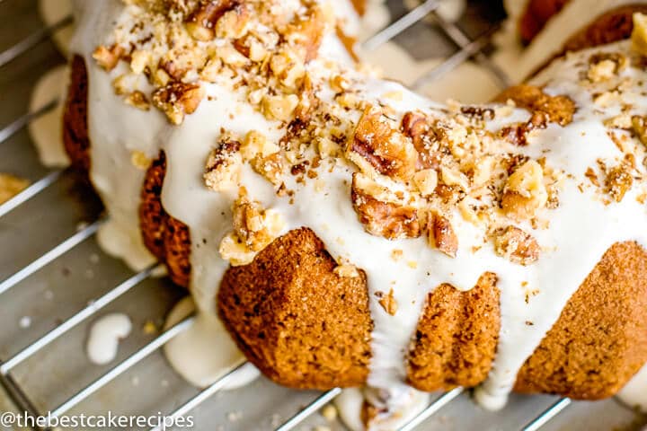 Easy Banana Bundt Cake Recipe with Cream Cheese Glaze and Walnuts on a wire rack