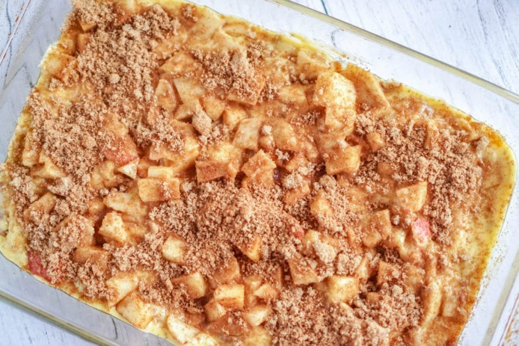 Apple Pie Cake unbaked with apples and sugar on top