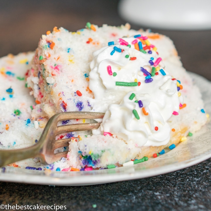 angel food cake with whipped cream and sprinkles on a plate
