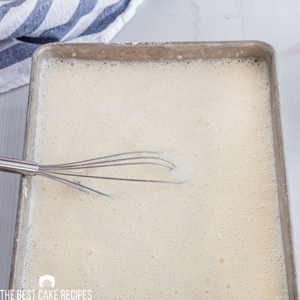 cake batter in a pan with whisk
