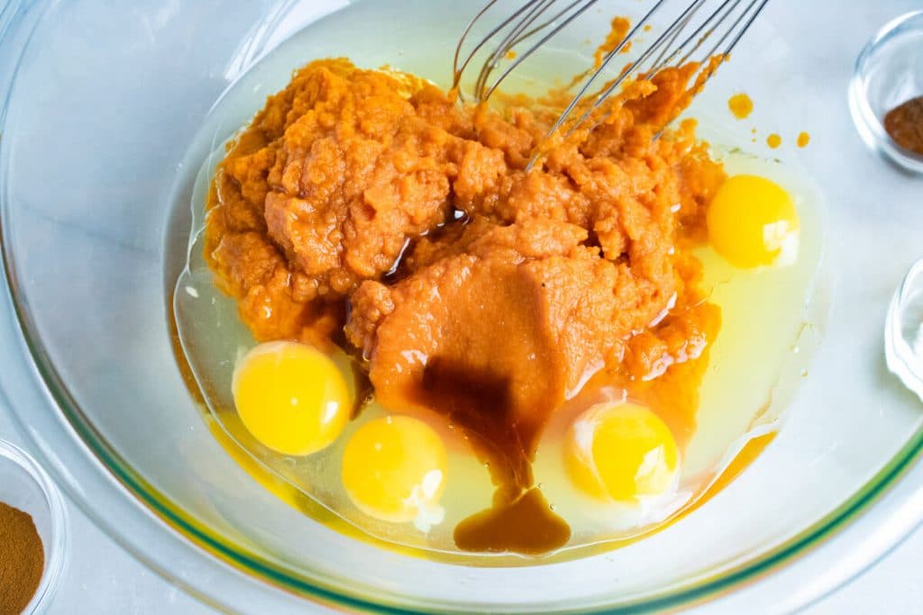 eggs and pumpkin in a bowl with a whisk