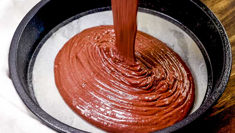 chocolate cake batter pouring in a pan