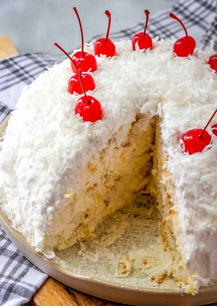 angel food snowball cake with cherries on top, one slice missing