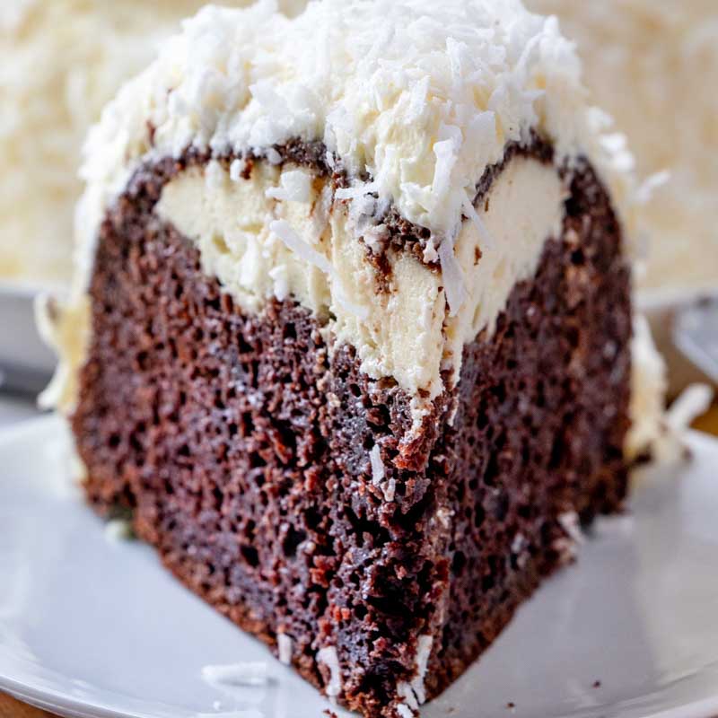 A piece of chocolate cake on a plate, with Cream cheese and coconut frosting