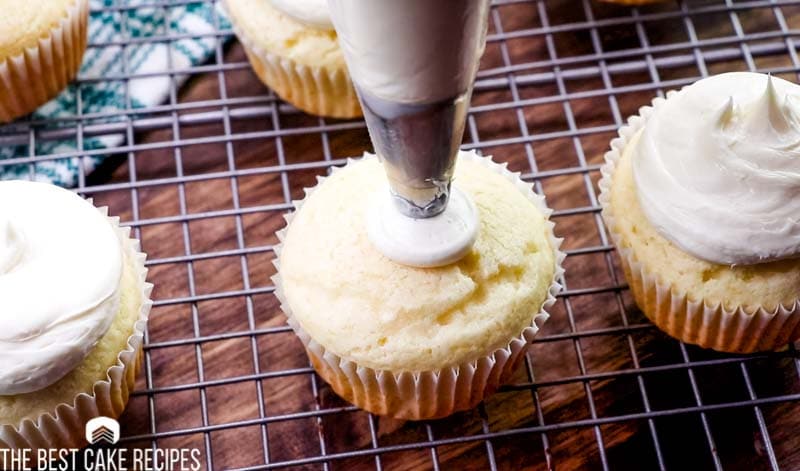 piping frosting on a cupcake