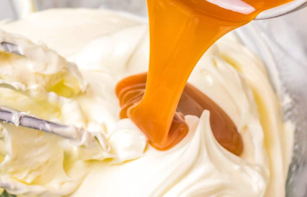 caramel pouring in cream cheese in a bowl