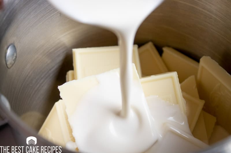 heavy cream pouring into a bowl of white chocolate