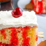 Jello Poke Cake with cherry on a plate