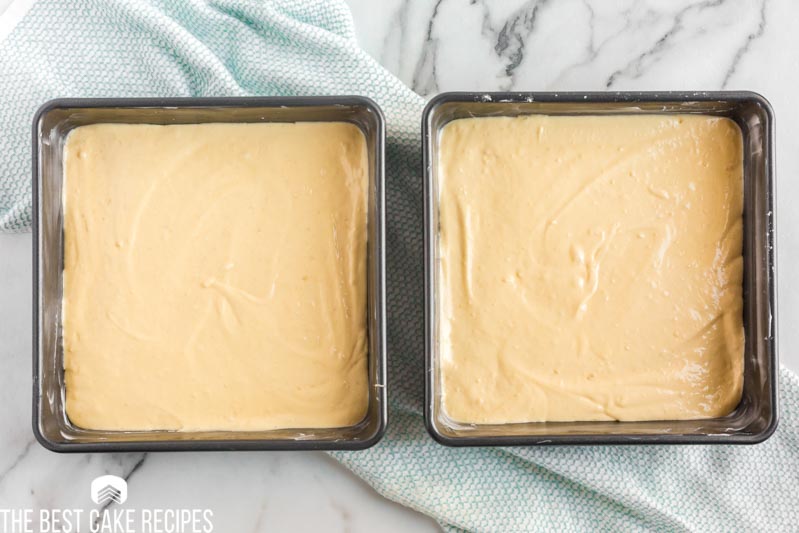 two square cake pans with unbaked cake batter