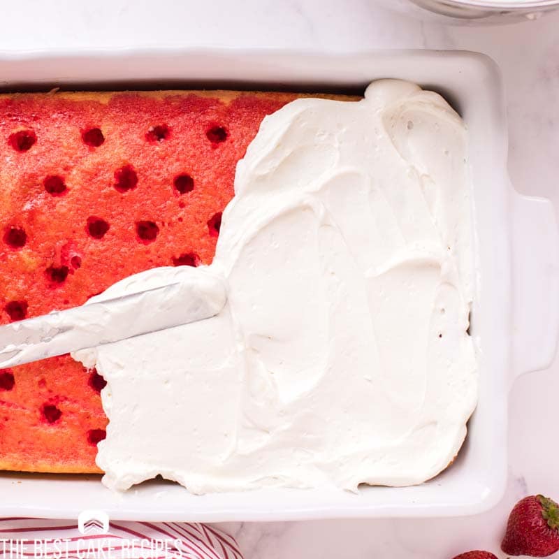 Cream Cheese Whipped Cream Frosting spreading on a jello cake