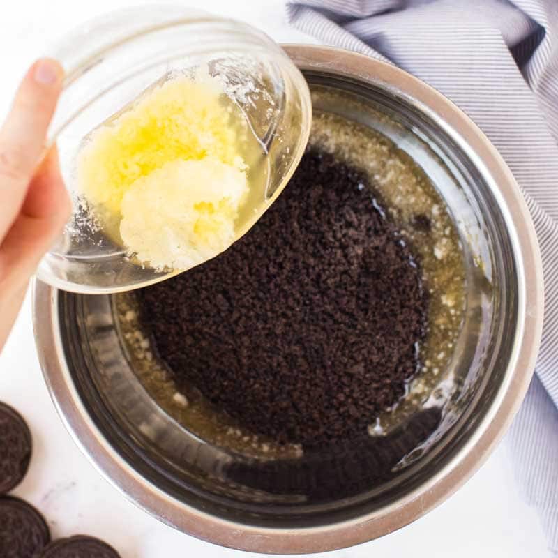 butter pouring in crushed oreos
