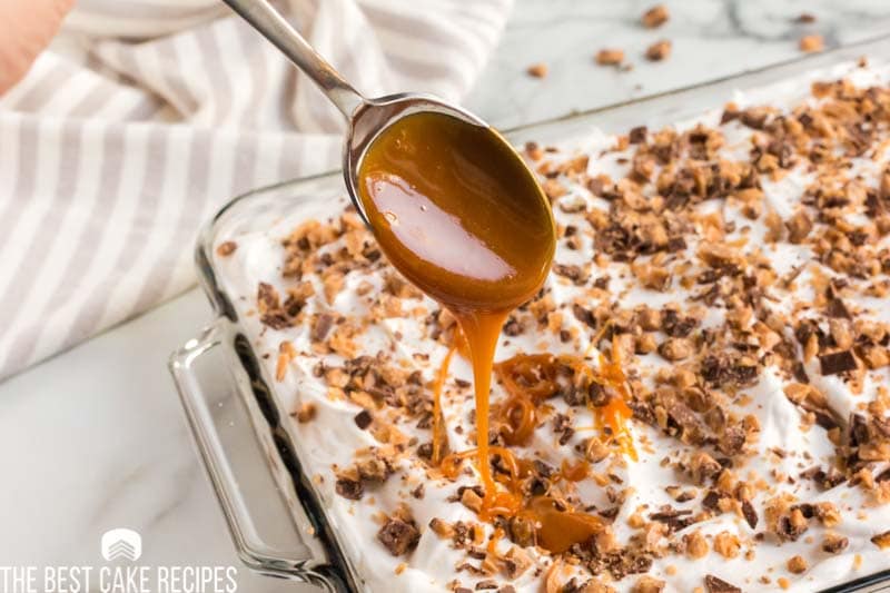 spoon drizzling caramel over a cake
