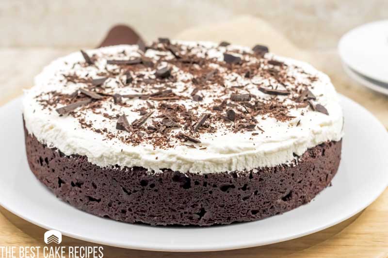 keto brownie cake with frosting and chocolate shavings