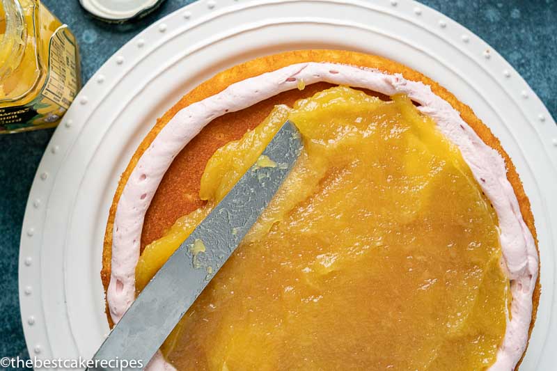 spreading lemon curd on a cake