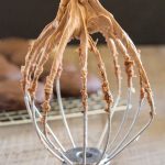 mocha frosting on a stand mixer whisk