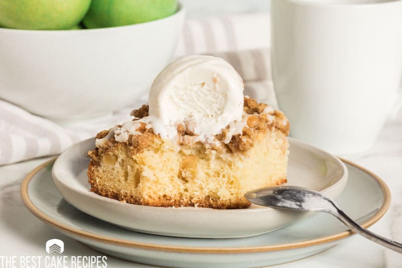 apple crisp coffee cake on a plate with a bite out of it