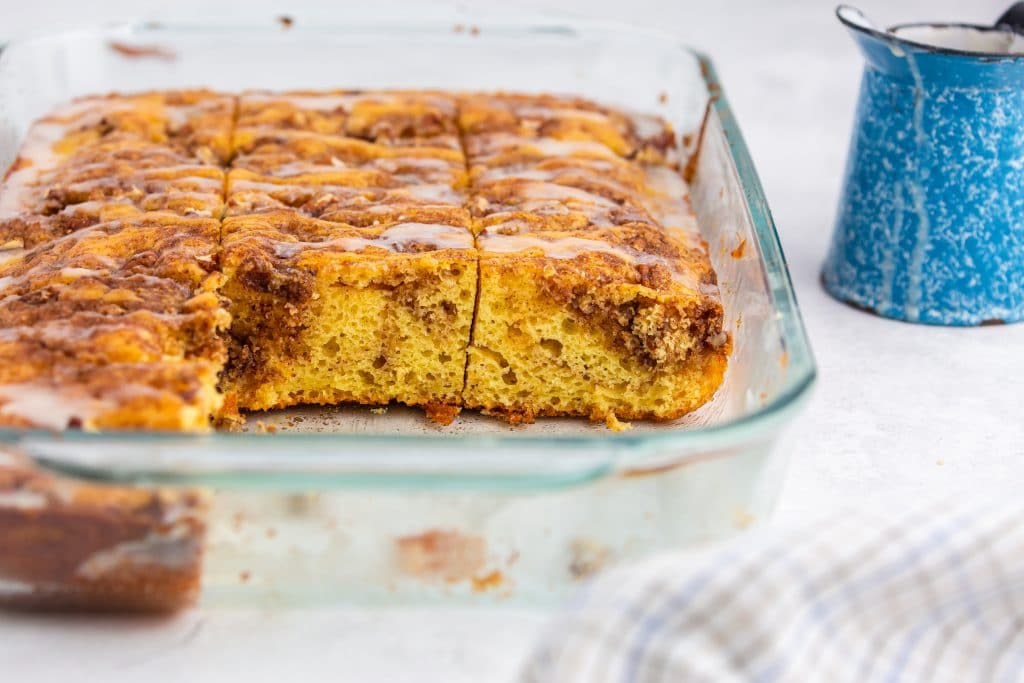 honey bun cake in a baking pan with slices missing