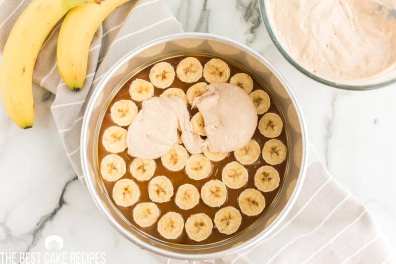 bananas in a cake pan with batter on top
