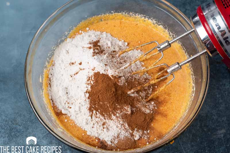 pumpkin cake batter with pumpkin pie spice mixing in