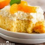 mandarin orange cake on a plate with a bite out