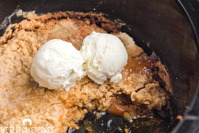 peach dump cake with ice cream in a slow cooker