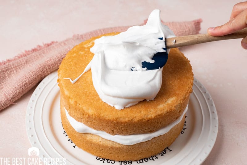 spreading frosting on a white cake