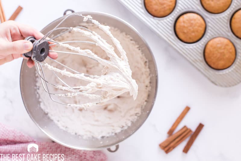 frosting on a whisk and in a mixing bowl