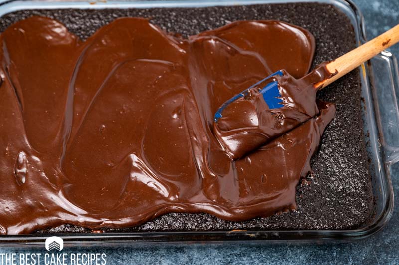 frosting a chocolate cake with chocolate frosting