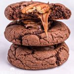 stack of chocolate caramel cookies with a bite out of one
