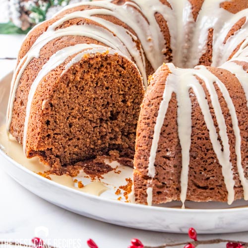 close up of gingerbread bundt cake on a plate with one slice out