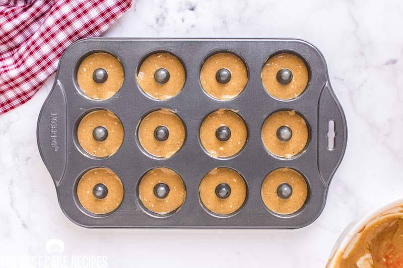 overhead view of unbaked donuts in a pan