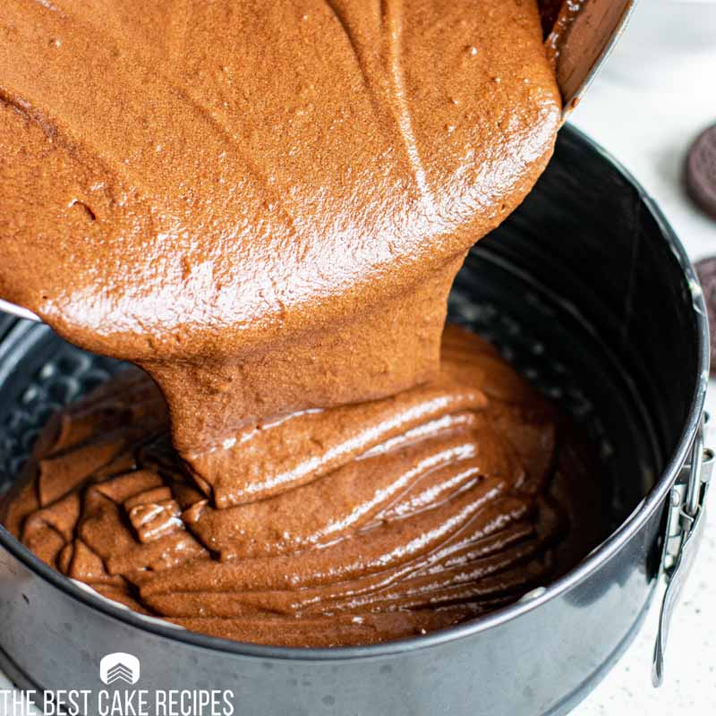 chocolate cake batter pouring into a pan