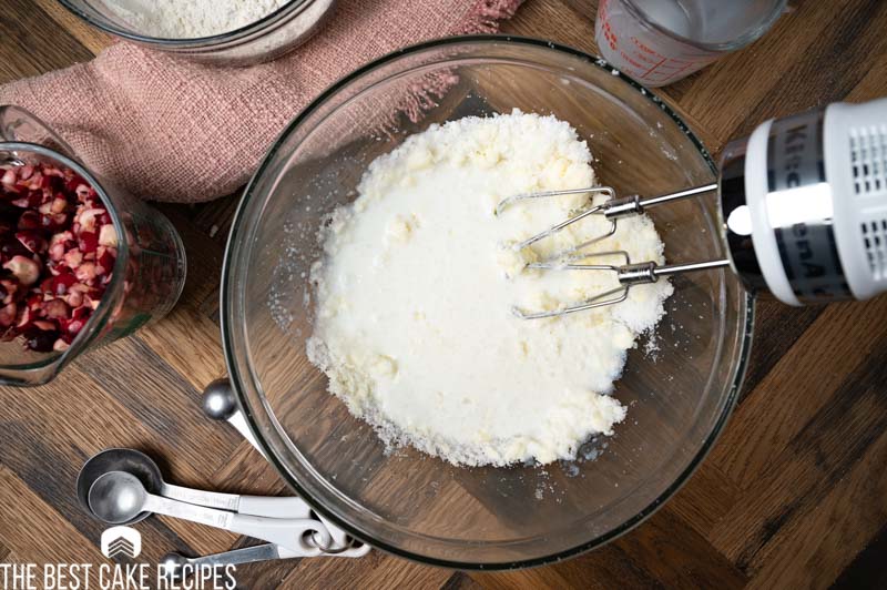 mixing milk into creamed butter and sugar in a bowl