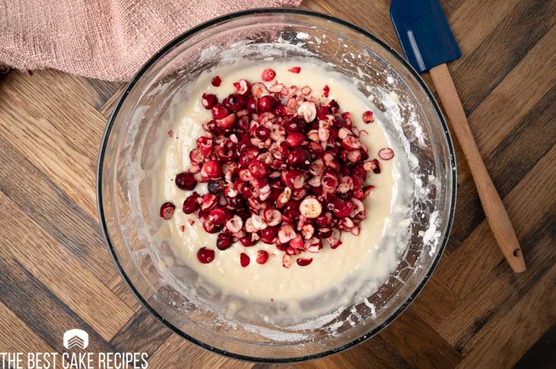 chopped cranberries over cake batter in a mixing bowl