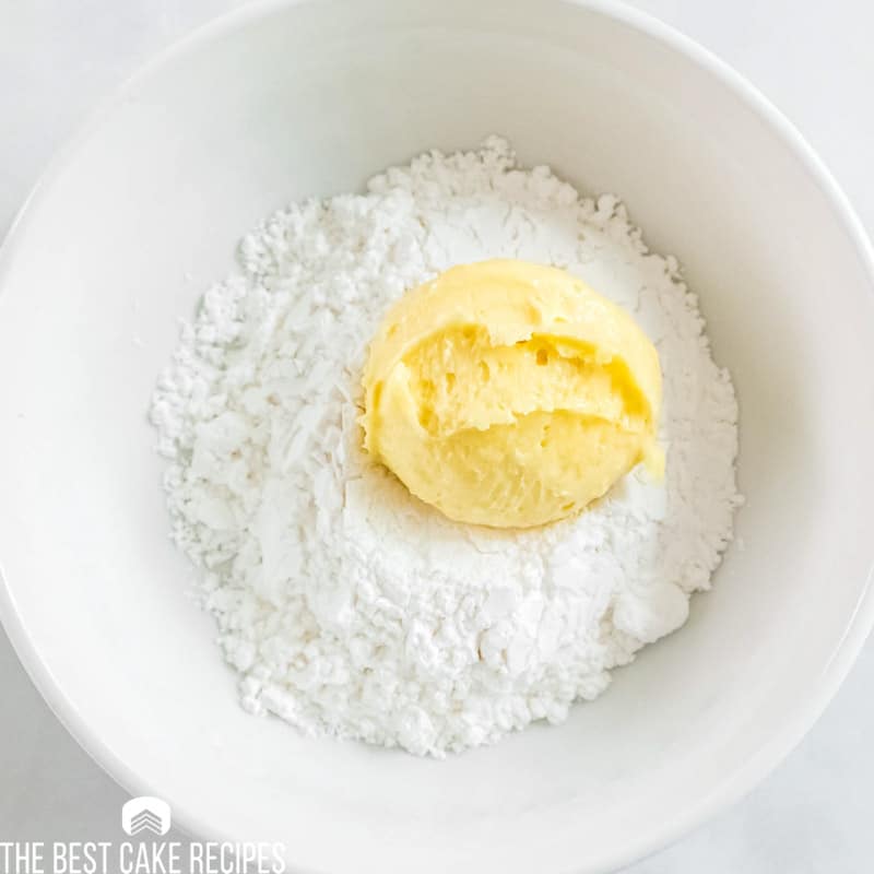 lemon cookie dough in a bowl of powdered sugar