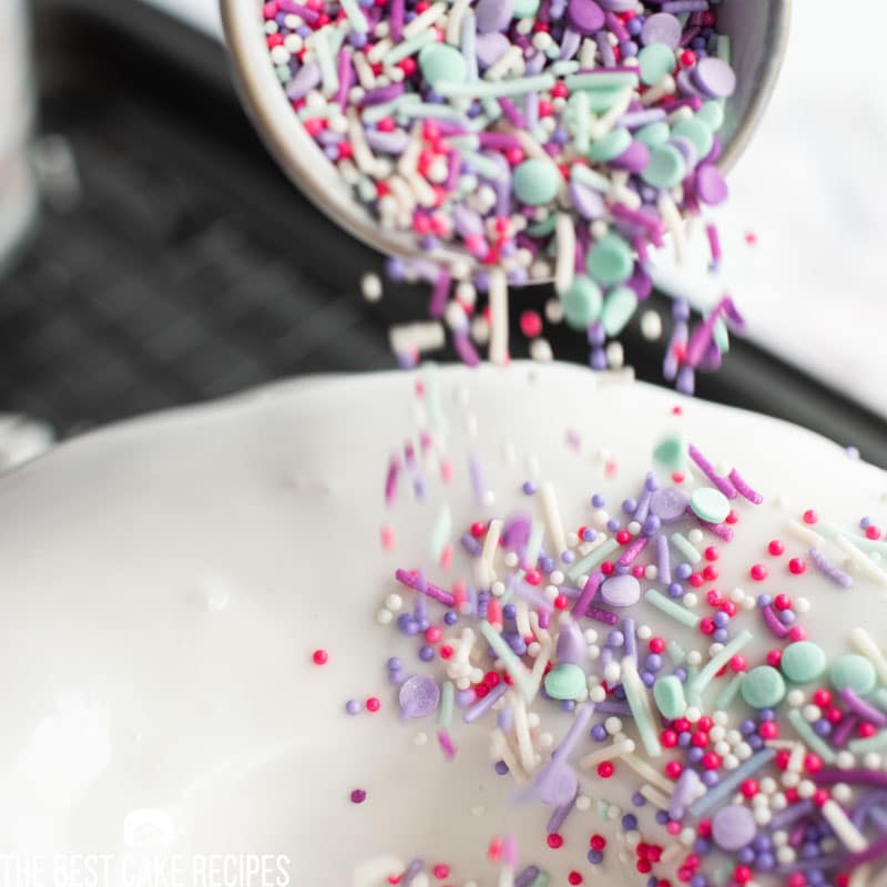 pouring sprinkles on a cake